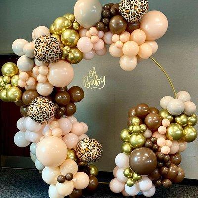 Safari themed round backdrop, with balloon garland with 5 color balloons.