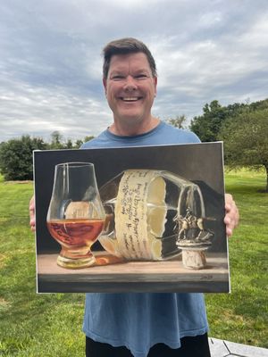 Max Savaiko Artist holding a Limited Edition Giclee of Blanton's Single Barrel Bourbon art