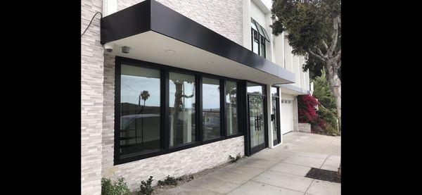 "Storefront" dark bronze hardware with insulated glass and herculite door system.