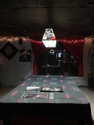 The pool table covered in band merch at the time