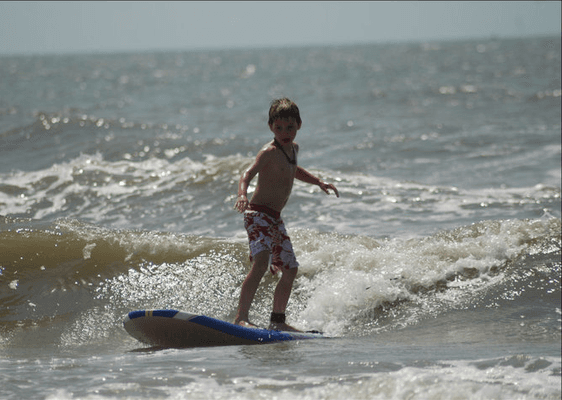 Tyler surfing a thigh high wave.