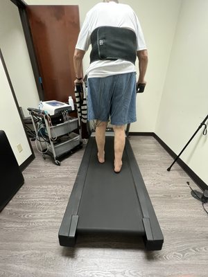 Helping a client increase core strength to promote stability while walking.