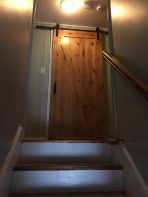 Sliding barn door installed on the second floor to make more space in a small bathroom