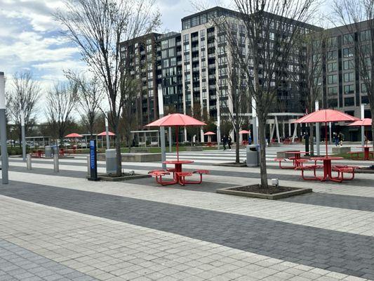 The paved plaza of the park has many picnic tables