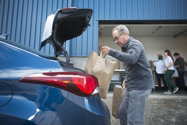 Volunteer loading their car to help deliver meals to clients living in King County.