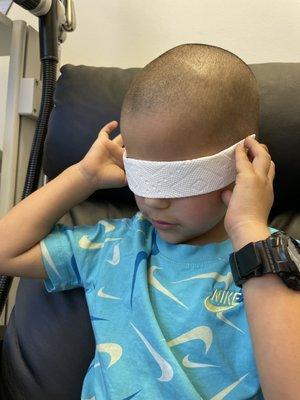 Covering his own eyes for his Treatment