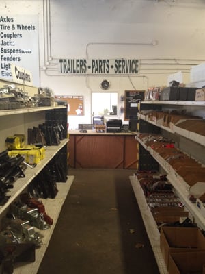 Full line of trailer parts including axles, brakes, hubs, springs, couplers, jacks, lights, hangers, tire & wheel assemblies.