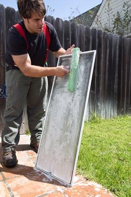 Drew hand washing a screen at a customer's home