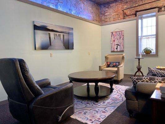 Photo of office interior (Photo description: two chairs, round table, art on walls)