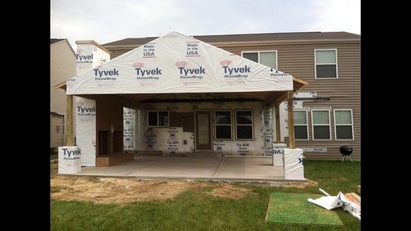 Adding a covered rear porch,stone  accents and an outdoor fireplace  creates that needed entertainment space .