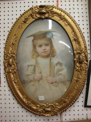 A striking turn of the century colorized photo in an oval bubble glass frame.