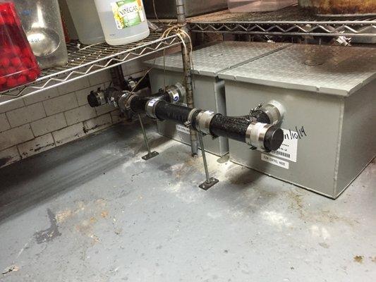 Commercial triple pot sink installation with sump pump and dual grease traps.