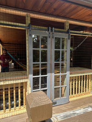 We hung barn doors on the outside of the cat aviary