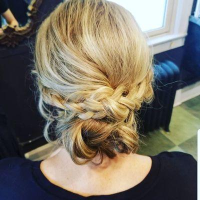 Romantic, soft braided updo with a messy bun