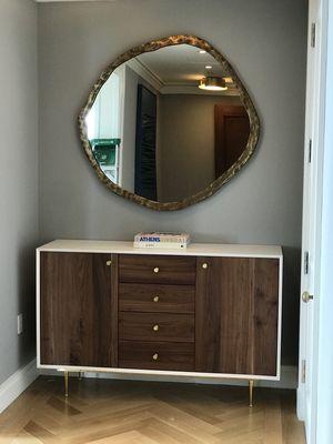 Luxury mirror hanging along with a beautiful wood dresser assembly