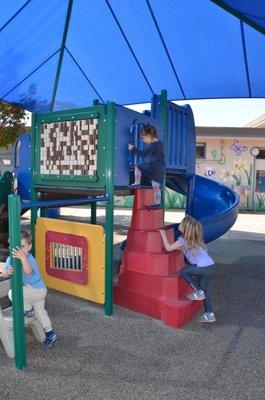 A safe outdoor play structure in the shade.