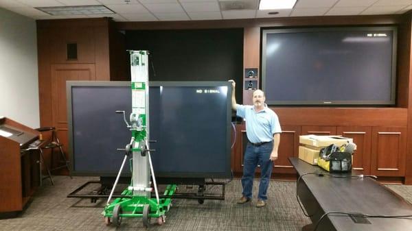 Installation of 2 700lbs, 103" Panasonic TVs in a conference room.