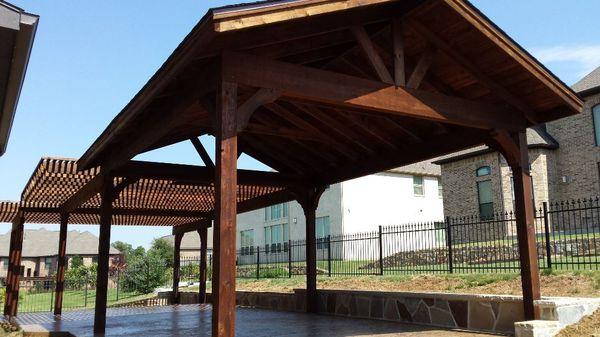 Patio cover, stonework, stamped concrete and arbor all designed and built by Green and Son. Iron fence also by G&S. Flowermound.