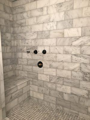 Shower with marble tile.