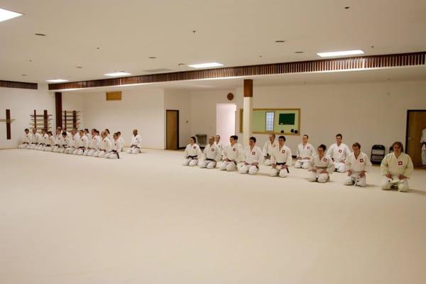 Back of the dojo, students wear dogi. Those who achieve black belt rank have their name engraved in a wood plaque and hung on the walls.