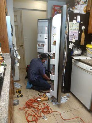 Kevin removing the back panel of our 11 year old Kitchen Aid refrigerator