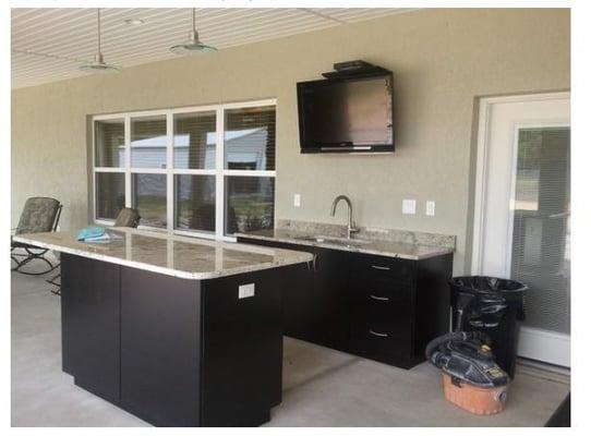 Outdoor kitchen featuring granite countertops and an island