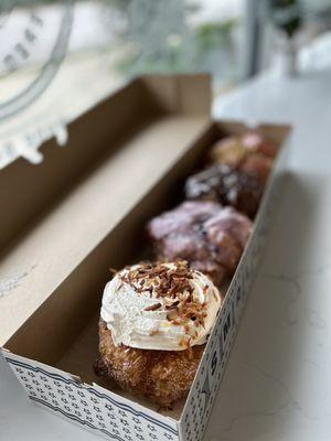 Coconut cream filled, blueberry, chocolate, and strawberry pistachio donuts