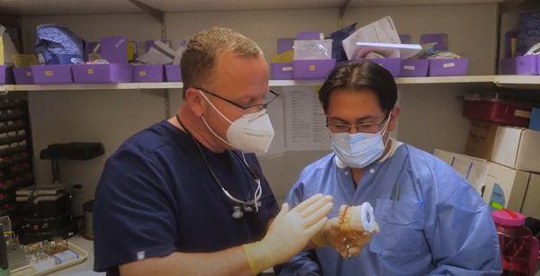 Dr. Markovitch explaining dental bridges to his dental assistant.