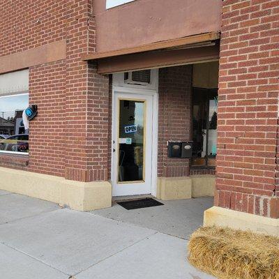 Front Entry
(Image shows red brick building with big windows and white framed glass door. )