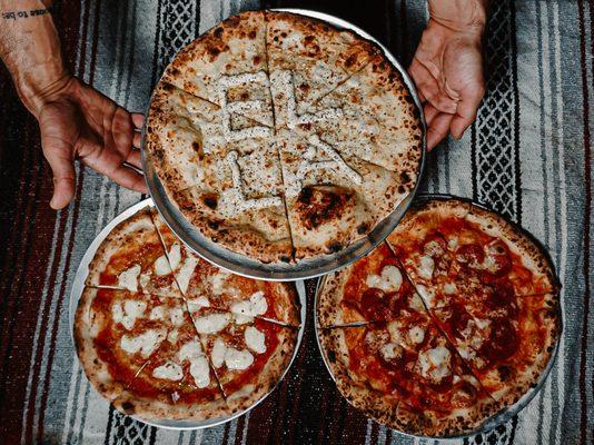 Our Cacio E Pepe pizza with our namesake spelled in our peppery and parm ricotta crema