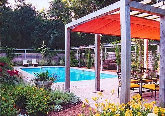 Swimming pool garden with shaded arbor; sandstone patio; lattice inlay fencing with arbor top; flowering shrubs, vines and peren