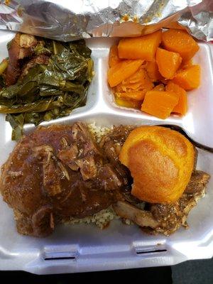 Smothered pork chops over dirty rice, candied yams, & collard greens