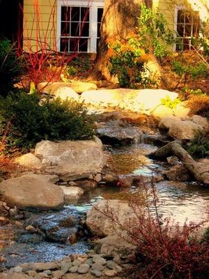 A winding River created in this Newton back yard blends right in with its woodland surrounding