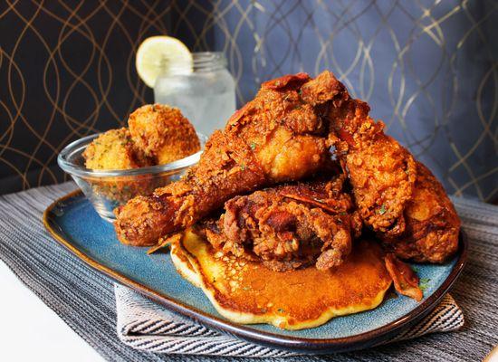 Famous Fried Chicken & Pancakes topped with (optional) crispy bacon crumbles and house-made syrup served with Panko potato balls