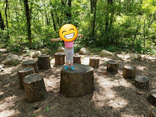 Logs for safely climbing on along the natural play trail.