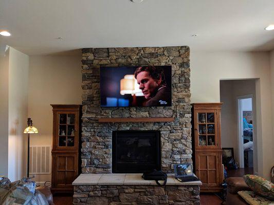 Tv mount on stone fireplace with in wall wire hiding