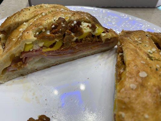 Spicy Italian Stromboli- Italian sausage, Genoa salami, ham, pepperoni, and capicola baked with banana peppers and mozzarella cheese.