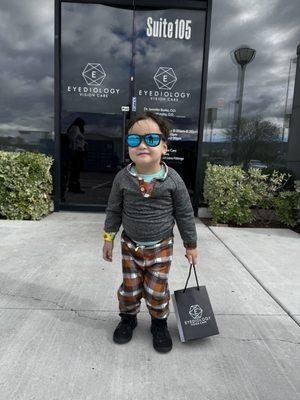 Our son posing in front of Eyediology with his new sunglasses