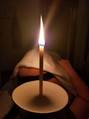 Removing wax by Ear Candling. A relaxing atmosphere of dim lighting, smell of cedar-lavender, sounds of a thunderstorm & fire crackling.