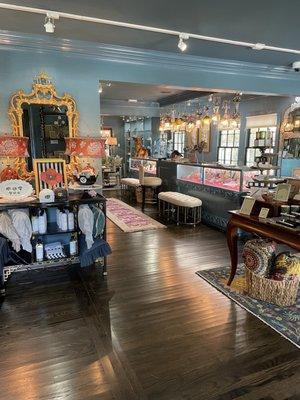 Our entry! A chinoiserie
 mirror and  a pair of Burgundy lamps resting on a black console with shelves and fretwork sides.