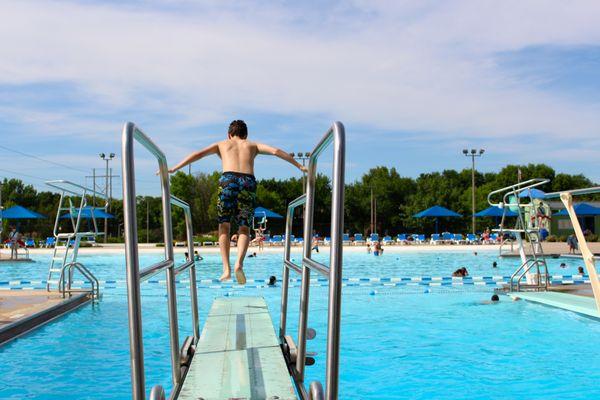 Young boy jumping off diving board at Ad Astra Pool. Photo by Wendy Delzeit.