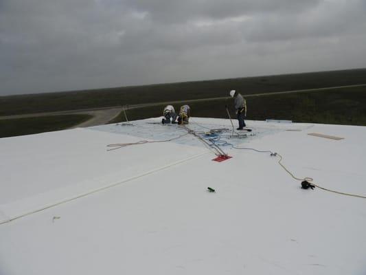 two roofers on top of a story roof repair