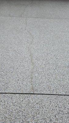 The existing concrete driveway crack reoccurred only one month after  Shark Skin Coating crack repair and new surface coating.