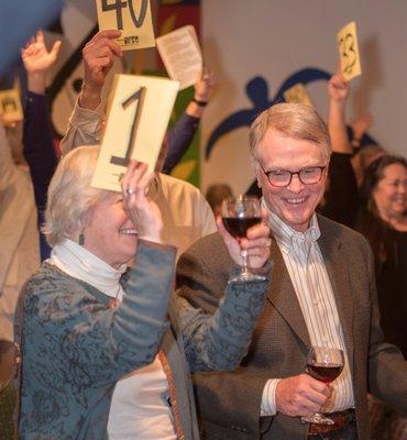 A couple at our annual Auction for the Arts fundraiser, bidding on some amazing local goods and services.