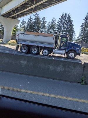 Untarped load on I-5 -  Shell Excavating dump truck.  Notice they had an automatic tarp that they could have secured their load of rocks.