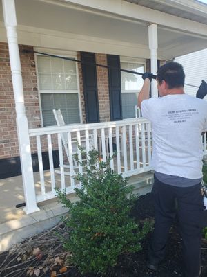 Owner Jason applying dust to a wasp entry point with a bee pole