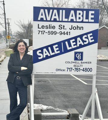 Leslie St. John next to a sign on Market St Camp Hill