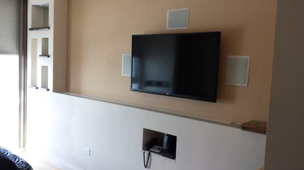 Flat screen TV installation including surround sound and shelf lighting