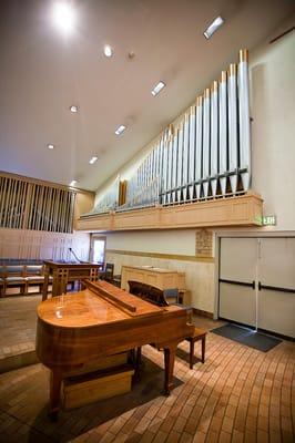 Grand piano with organ pipes.