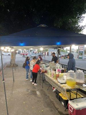 The taco stand is under two tents by the intersection